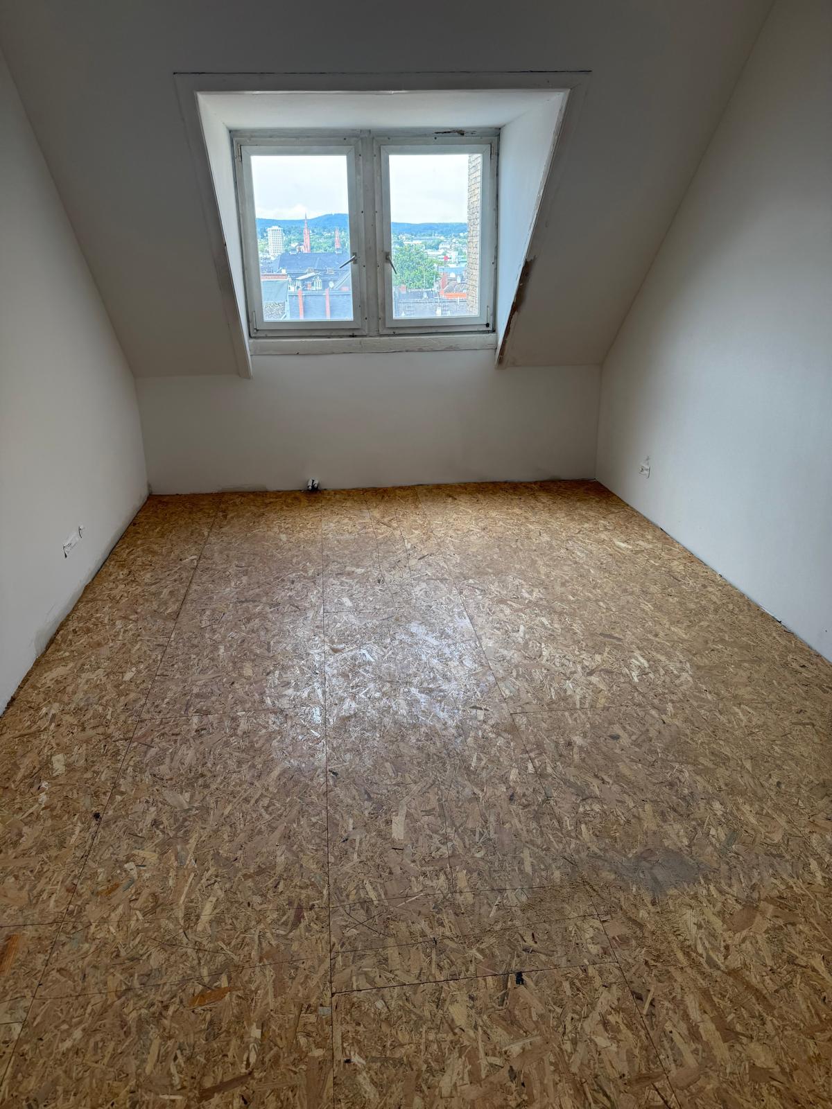 Helles Dachgeschosszimmer mit Gaubenfenster