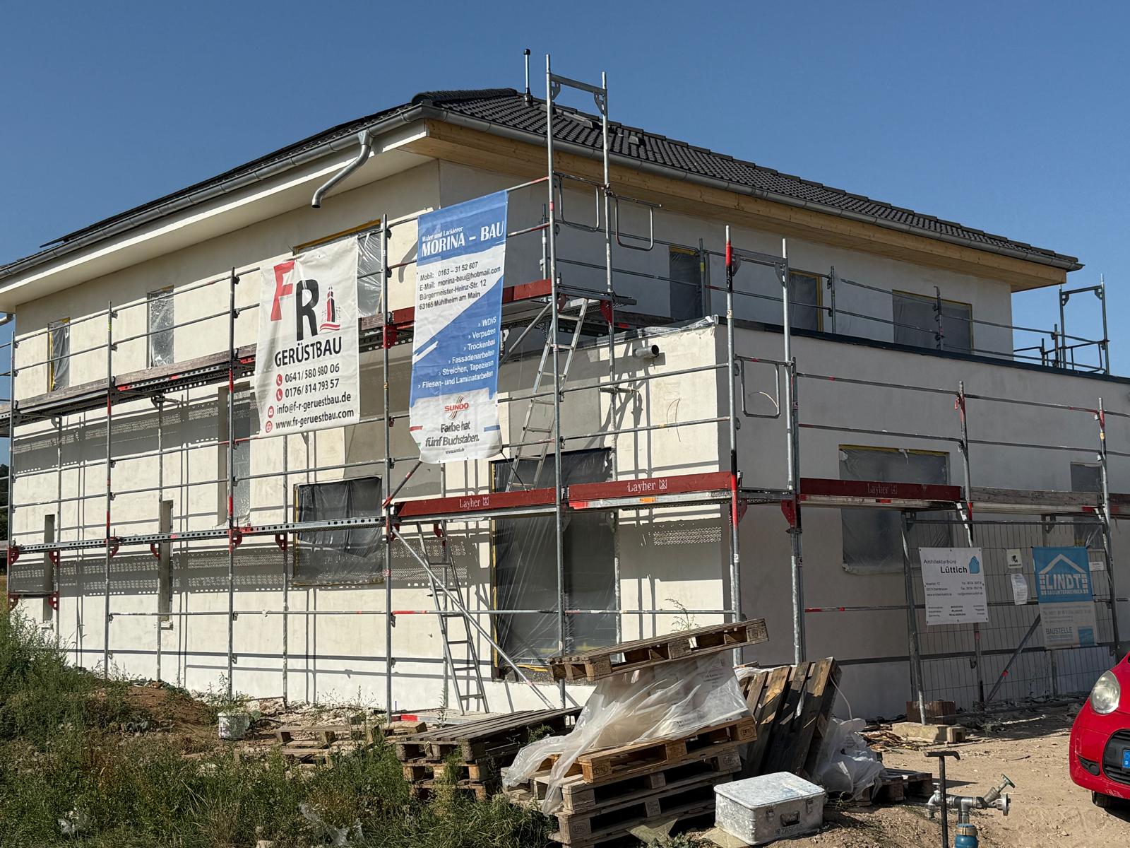 Neubau mit Gerüst und angebrachtem Wärmedämmverbundsystem vor dem Oberputz