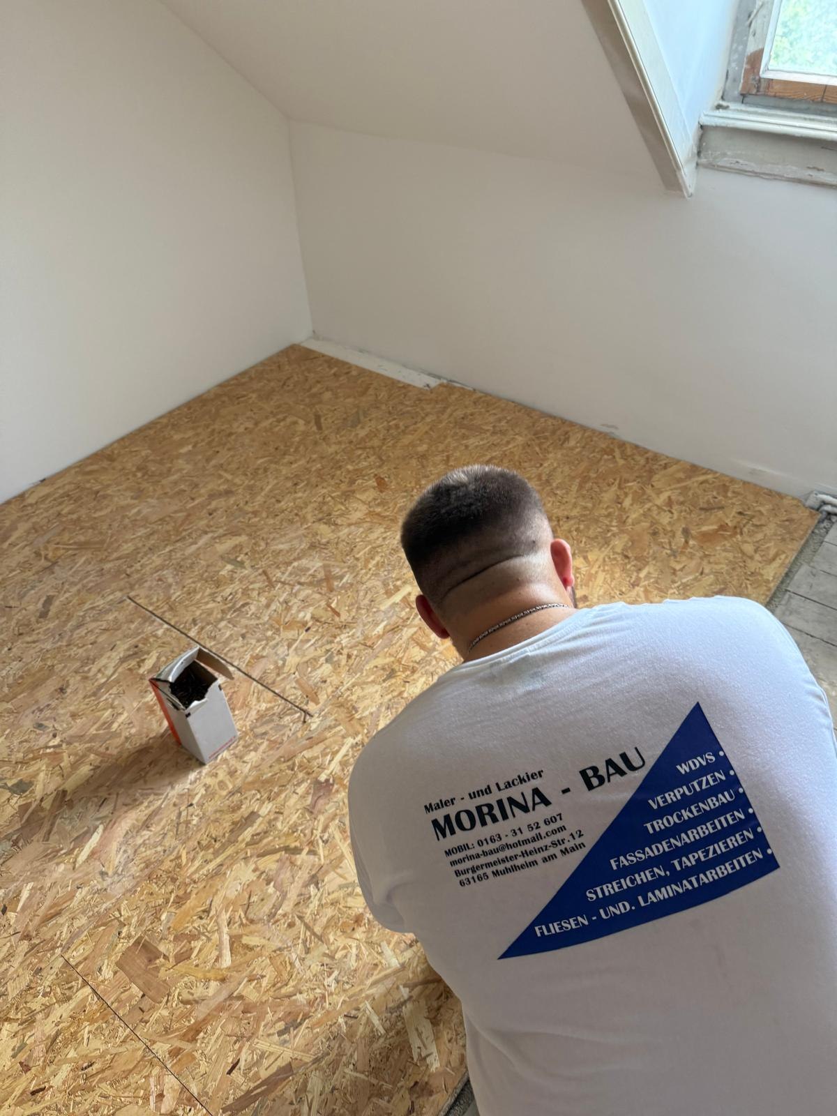 Mitarbeiter von Morina-Bau verschraubt OSB-Platten als Unterboden