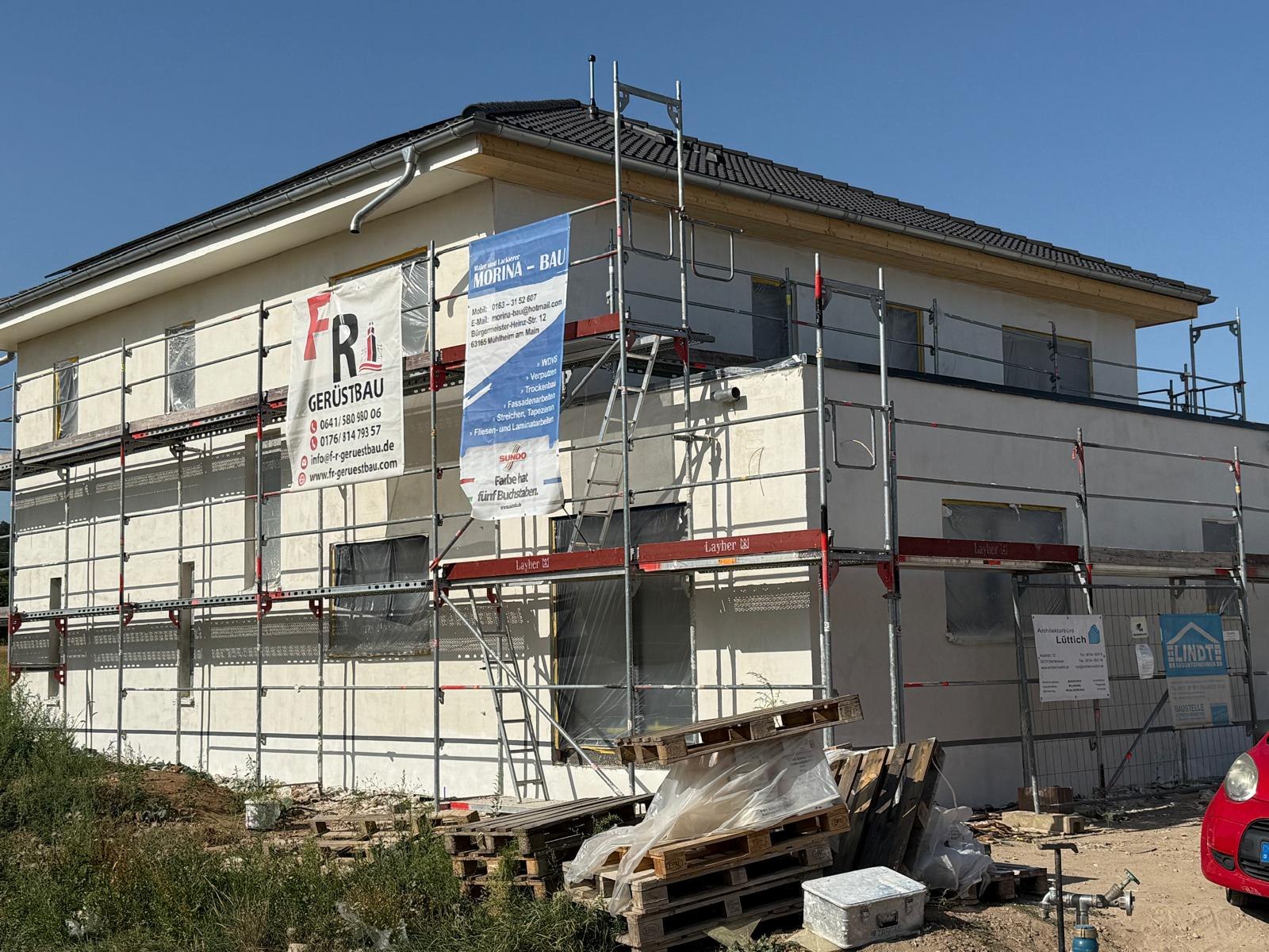 Fassade im Gerüst mit Bauschild von Morina-Bau und abgeklebten Fenstern