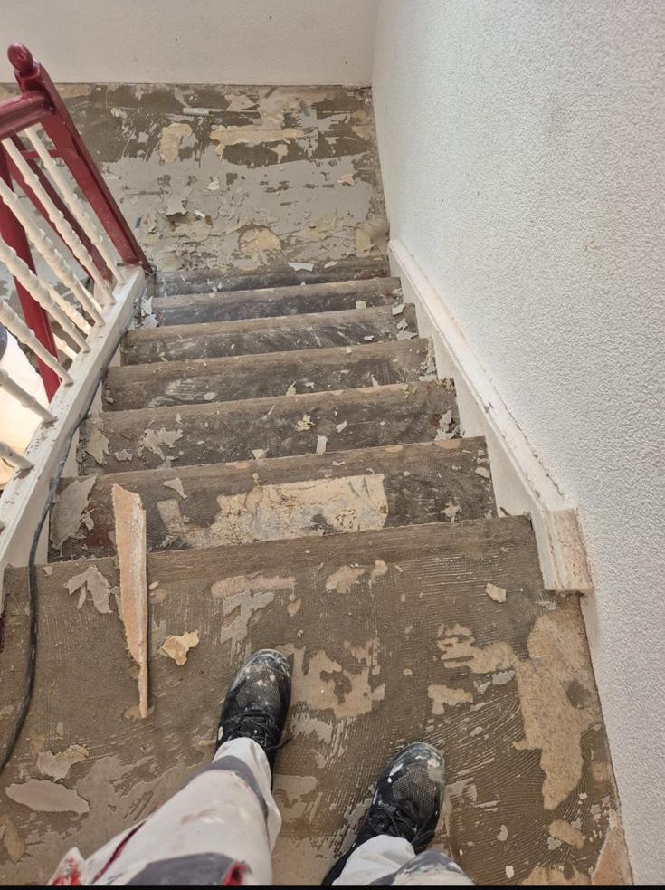 Treppe mit abgerissenem Belag, Reste und Kleberspuren auf den Stufen