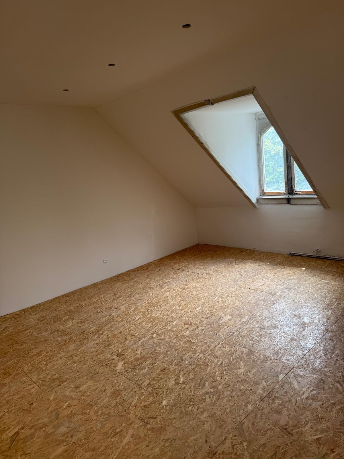 Ausgebautes Dachgeschosszimmer mit fertig verspachtelter Dachschräge
